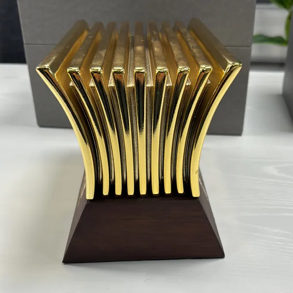 Stepped gold-finish award standing on a dark wooden base